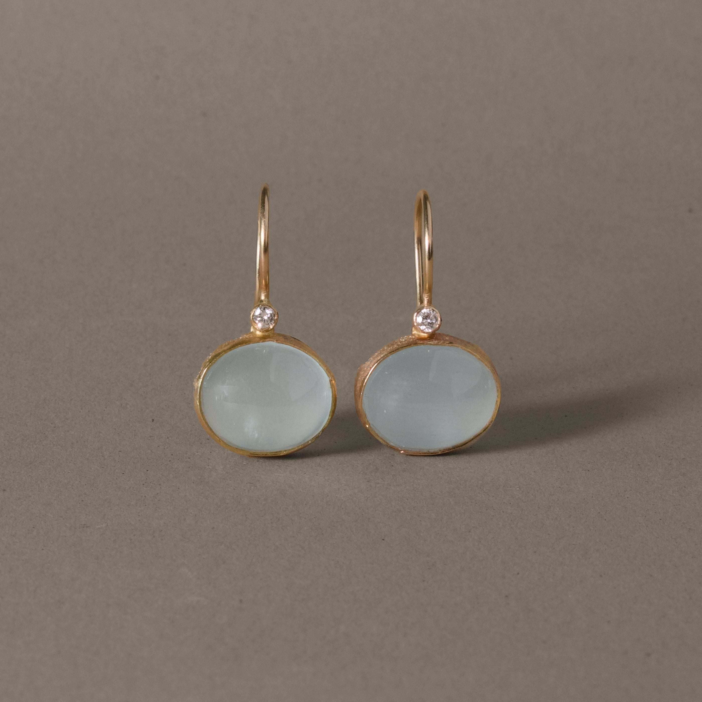 Diamond aquamarine earrings in gold featuring milky aqua stones and pure diamonds.