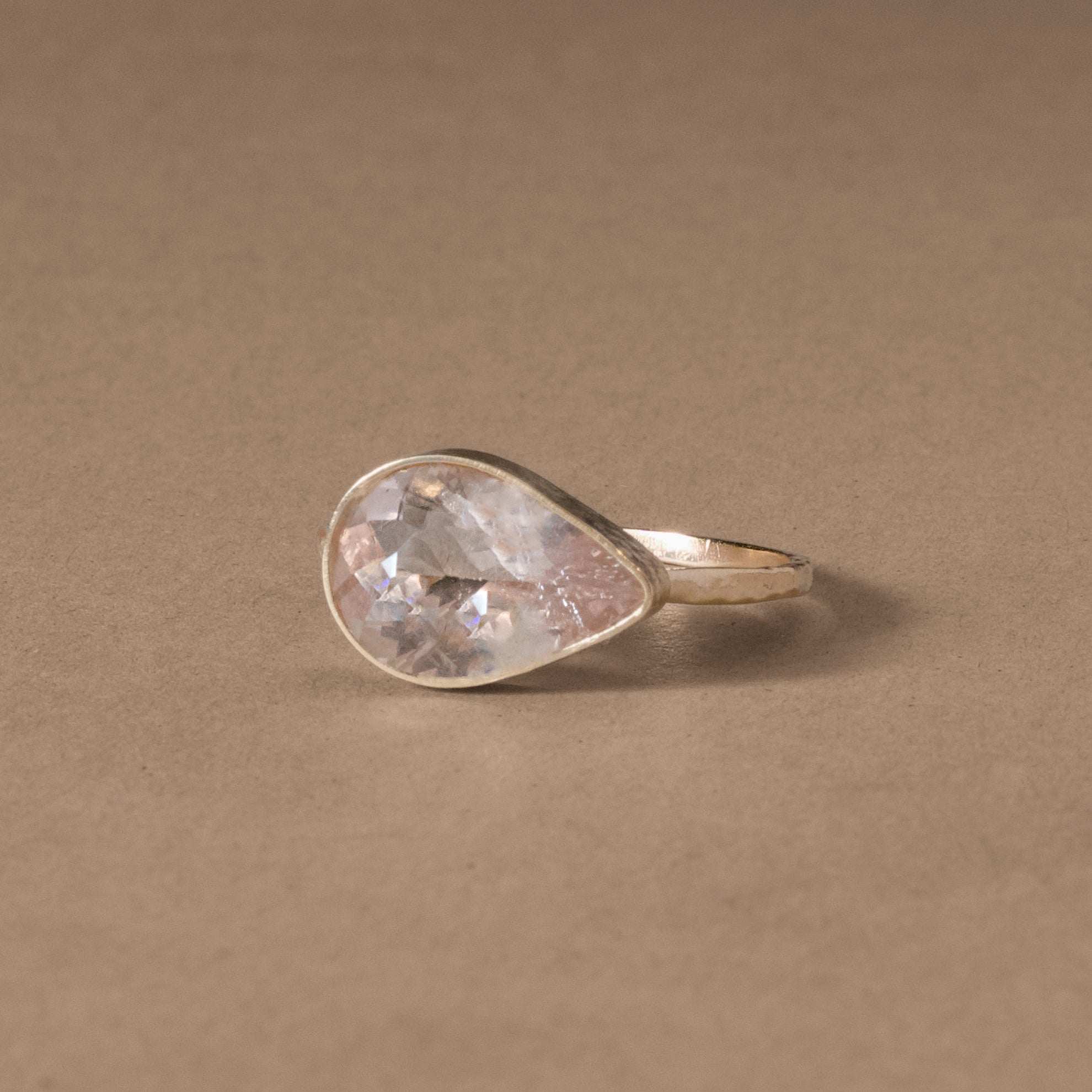 Pear-shaped faceted Morganite ring in 14ct hammered gold setting.