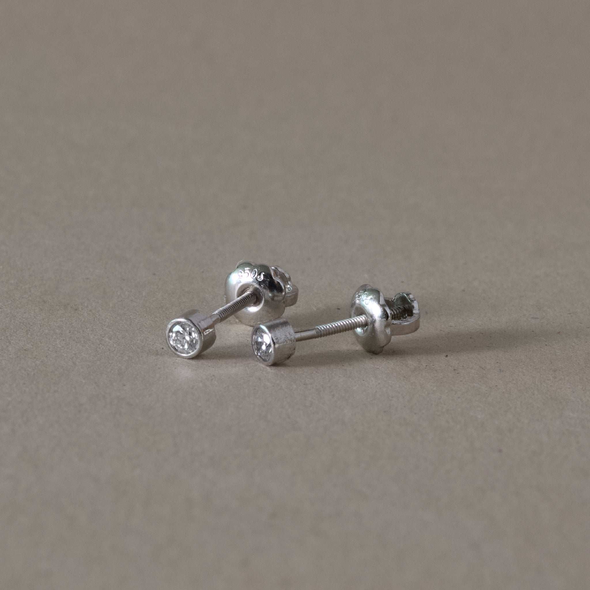 Platinum diamond stud earrings with bezel set natural diamonds.