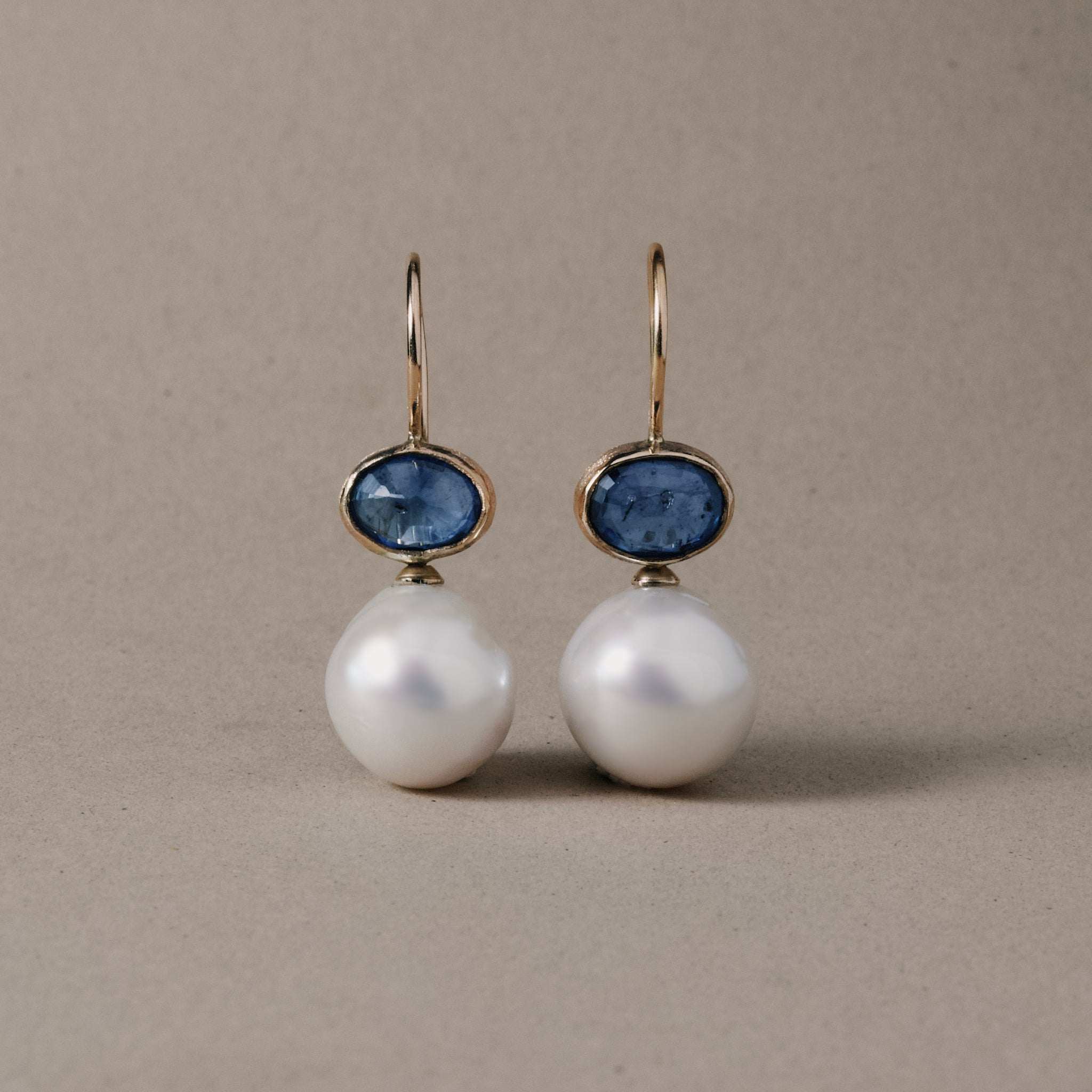 Handmade sapphire pearl earrings in 14ct gold with freshwater pearls and deep blue sapphires.