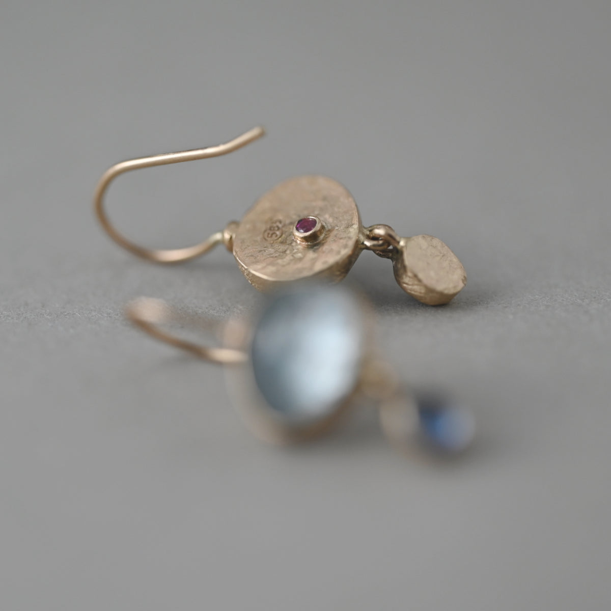 Sera aquamarine and sapphire earrings in 14ct gold showing back with vermilion signature ruby gemstone