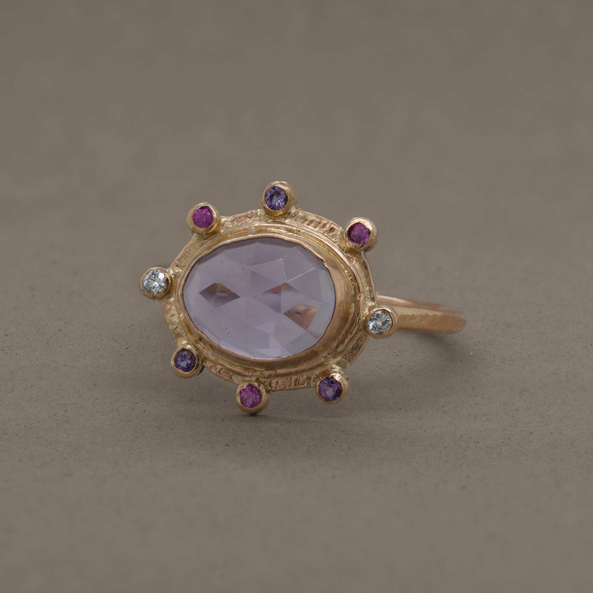 Amethyst ring with gold band, accented by sapphires and diamonds.