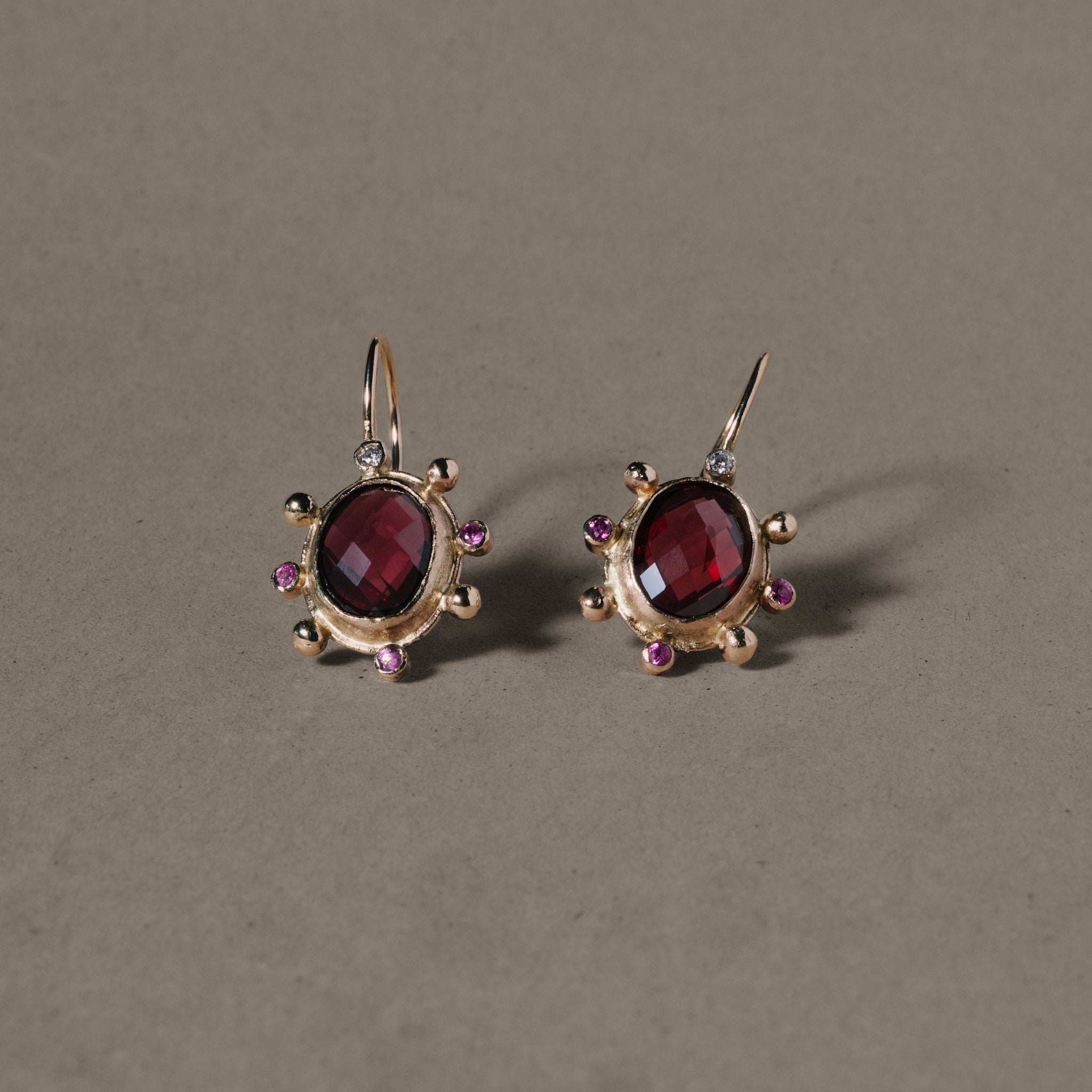 Rhodolite garnet earrings with gold, pink sapphires, and diamonds.