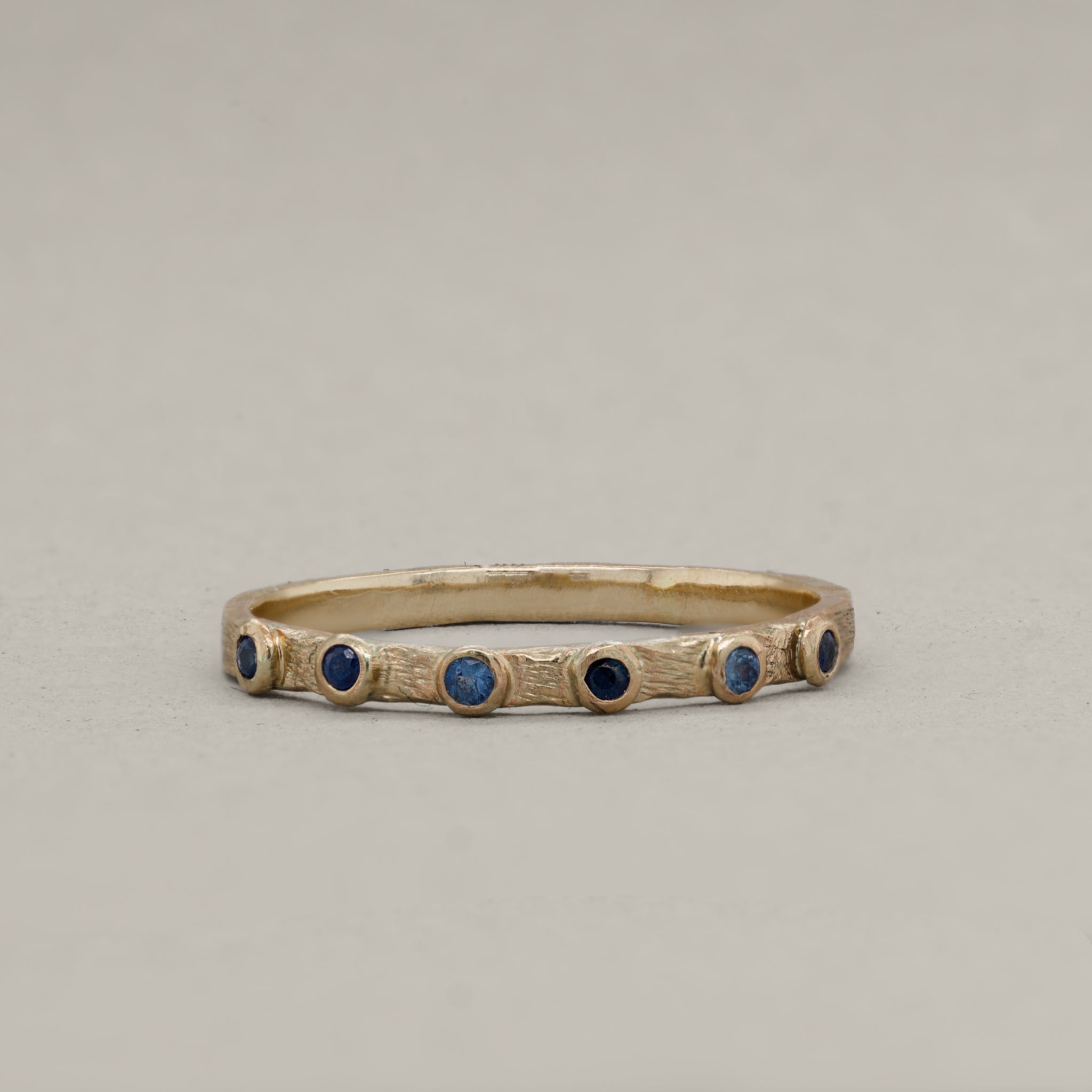 Gold band ring with small round blue sapphires, Stellata Sapphire Ring design.