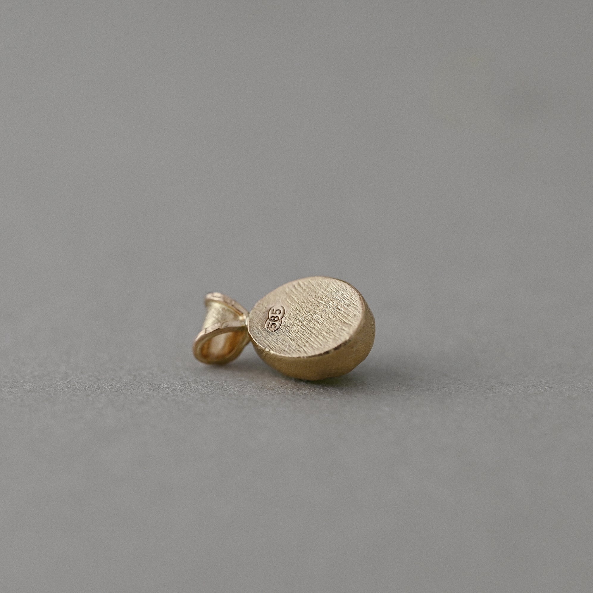 Back of a handcrafted 14ct solid gold Arizona peridot pendant with 585 hallmark and satin finish.
